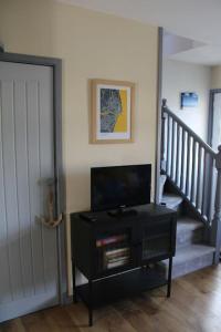 a living room with a door and a tv and stairs at Cosy 3 bedroom house close to beach in Lowestoft