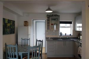 a kitchen with a table and a table and chairs at Cosy 3 bedroom house close to beach in Lowestoft