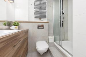 a bathroom with a toilet and a shower at Warsaw Magellana Apartment by Renters in Warsaw