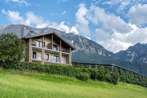 een gebouw op een heuvel met bergen op de achtergrond bij Appartements Panorama in Vols am Schlern