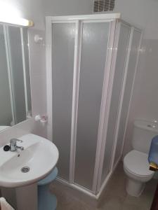 een badkamer met een wastafel, een toilet en een douche bij Pensión los Ángeles in La Puebla de Cazalla