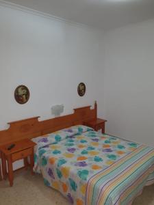 拉普埃夫拉德卡薩利亞的住宿－Pensión los Ángeles，卧室内一张带五颜六色棉被的床