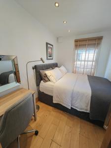 1 dormitorio con cama, escritorio y ventana en Cambridge city centre immaculate 2 bed apartment, en Cambridge