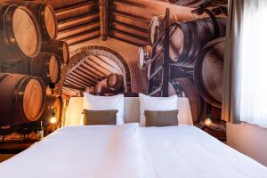 a bedroom with a bed and a bunch of wine barrels at Dormio Wijnhotel Valkenburg in Valkenburg +42 photos