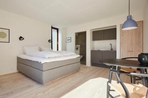 1 dormitorio con cama, mesa y cocina en Vesterlandet, en Vestervig