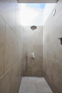 uma casa de banho com um chuveiro e paredes em azulejo em Vesterlandet em Vestervig