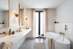 een witte badkamer met een bad en een spiegel bij Magno Apartments Cabo Noval Luxury House in Sevilla