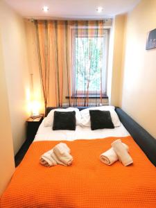 a bedroom with a large bed with two towels on it at Apartament Coffee Zakopane in Zakopane