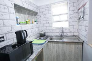 a kitchen with a sink and a microwave at Amazing Grace Hostel and International Serviced Apartments in Ibadan