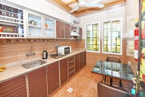 a kitchen with a sink and a glass table at OYO 139 Al Ghadeer Hotel Apartments in Barka