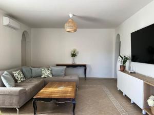 a living room with a couch and a flat screen tv at Comfortable family house with pool and jacuzzi in Costa de Antigua