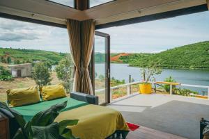 a bedroom with a large window with a view of a river at Thỏ Non Garden Villa Bảo Lộc in Bao Loc