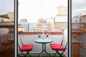 a table with two chairs and wine glasses on a balcony at Ático Teatro Romano - Terraza - Ascensor in Zaragoza +17 photos