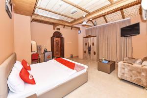 a bedroom with a bed and a tv and a couch at OYO 139 Al Ghadeer Hotel Apartments in Barka