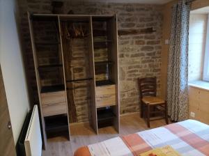 a bedroom with a bed and some wooden shelves at Gîte Massatho tout confort avec jardin in Fay-en-Montagne