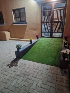a courtyard of a house with a green lawn at Pinto City Motel in Kempton Park