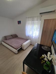 a small room with a bed and a table at Apartments Lana - 30 m from the sea in Seline