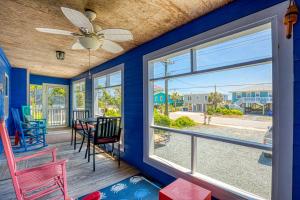 een eetkamer met een blauwe muur en een plafondventilator bij Blue Crab in Surf City