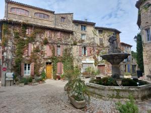 a stone building with a fountain in front of it at Côté Terrasse in Apt