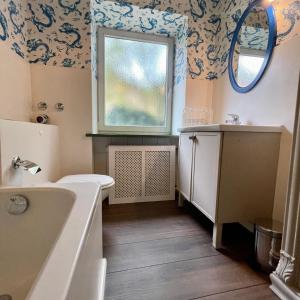 a bathroom with a sink and a toilet and a window at Hochfeld City Apartment in Tegernsee