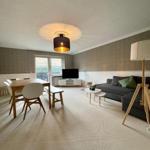 a living room with a couch and a table at Hochfeld City Apartment in Tegernsee