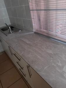 a kitchen counter with a sink and a window at Royal Nest Guest House in Vereeniging