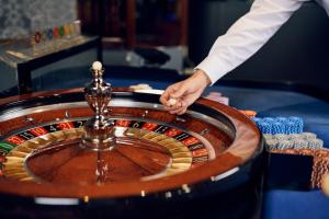 un hombre está sosteniendo una ruleta en un casino en Hotel Paris en Opatija