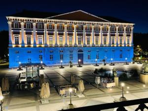Un grand bâtiment bleu avec des lumières allumées la nuit dans l'établissement Standing et confort, emplacement idéal centre ville, vue magnifique, à Chambéry