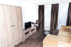a living room filled with furniture and a tv at HOF HOTEL in Kaunas
