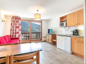 a kitchen and living room with a table and a couch at Vacancéole - Le Dôme des Rousses in Vaujany