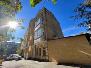 an old brick building with the sun in the sky at Квартира в центре Киева in Kyiv