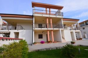 a house with a balcony and a yard at Lina apartments in Ginosa Marina