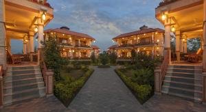 a mansion with a pathway leading to a courtyard at Green Park Chitwan in Sauraha