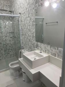 穆庫熱的住宿－Escalada Hospedagens e Eventos，一间带水槽、卫生间和镜子的浴室
