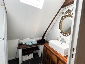 ein Bad mit einem Waschbecken und einem Spiegel in der Unterkunft Le Gîte Marguerite - Calvados : vue panoramique sur la Normandie in Hermival-les-Vaux