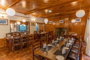 a dining room with tables and chairs and a fireplace at Hotel Negi's Mayflower A heritage Since 1965 in Manāli