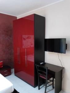 Un armario rojo con un escritorio y un televisor. en Bed & Breakfast 21, en Gela