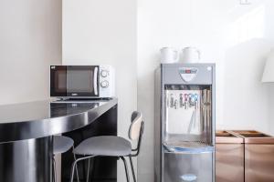 een kleine keuken met een koelkast en een magnetron bij Knock Knock Style Inn in Taitung