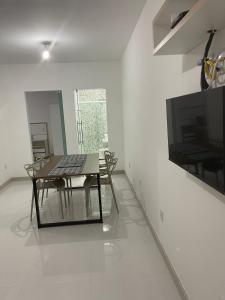 a dining room with a table and a television at Escalada Hospedagens e Eventos in Mucugê