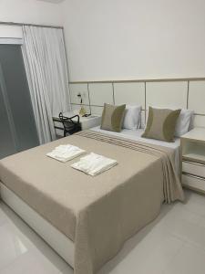 ein Schlafzimmer mit einem großen Bett mit zwei Handtüchern darauf in der Unterkunft Escalada Hospedagens e Eventos in Mucugê