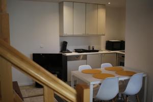 a kitchen with a table and chairs in a kitchen at The Suite Escape Apartment Sand in Sint-Lievens-Houtem