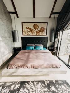 a bedroom with a large bed with blue pillows at Novella in Varkala