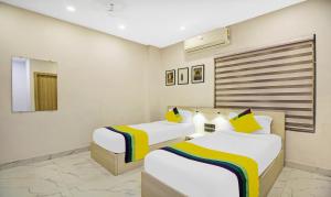 a hotel room with two beds and a mirror at Itsy By Treebo - Transit Express in Kolkata