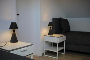 een woonkamer met een bank en 2 lampen op tafels bij The Suite Escape Apartment Sand in Sint-Lievens-Houtem