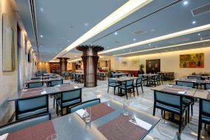een eetkamer met tafels en stoelen in een restaurant bij Mercure Gold Hotel, Jumeirah, Dubai in Dubai