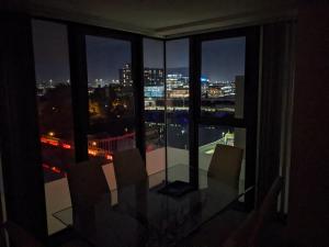 a room with a view of a city at night at Glasgow City Centre Waterfront Apartment in Glasgow