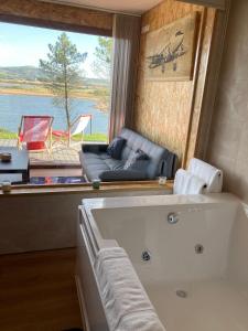uma banheira num quarto com uma grande janela em AIR FERVENZA em Dumbría