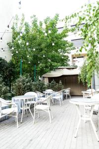 - un ensemble de tables et de chaises sur une terrasse dans l'établissement HOF HOTEL, à Kaunas