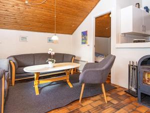sala de estar con mesa, sillas y chimenea en 10 person holiday home in Glesborg, en Fjellerup Strand