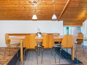 a dining room with a wooden table and chairs at 10 person holiday home in Glesborg in Fjellerup Strand